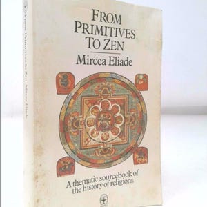 May include: A book titled "From Primitives to Zen" by Mircea Eliade. The book cover features a colorful mandala design and the text "A thematic sourcebook of the history of religions".