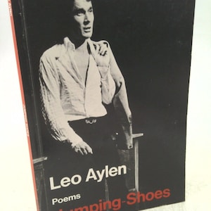May include: A black and white photo of a man in a white shirt and black pants. The photo is on the cover of a book titled "Leo Aylen Poems Jumping-Shoes".
