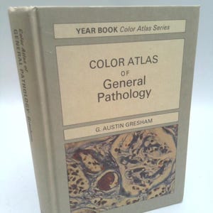 May include: A hardcover book titled Color Atlas of General Pathology by G. Austin Gresham from the Year Book Color Atlas Series. The cover is light gray with a rectangular inset featuring a microscopic tissue sample in shades of brown and blue.
