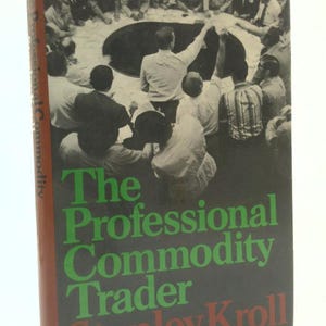May include: A hardcover book titled "The Professional Commodity Trader" by Stanley Kroll. The cover is black with green and red text. The image on the cover shows a group of people gathered around a table.