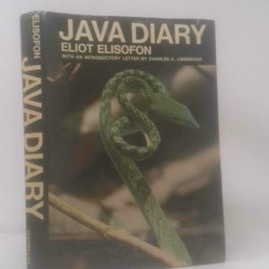 May include: A hardcover book titled Java Diary by Eliot Elisofon with an introductory letter by Charles A. Lindbergh. The black cover features a photograph of a green snake coiled on a branch, with the title text in large white letters.