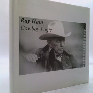 May include: A hardcover book titled "Ray Hunt Cowboy Logic" features a black and white photograph of a man wearing a cowboy hat. The book's cover is a light gray color, with the title and author's name printed in black.