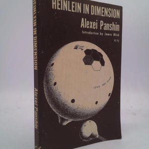 May include: A brown book cover with the title "Heinlein in Dimension" by Alexei Panshin. The cover features a black and white illustration of a spaceship in space.