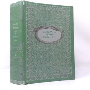 May include: A green hardcover book titled Harry Potter and the Goblet of Fire. The front cover features an embossed snake design encircling the title text. The spine displays the title and the number 4. The cover has a textured pattern.
