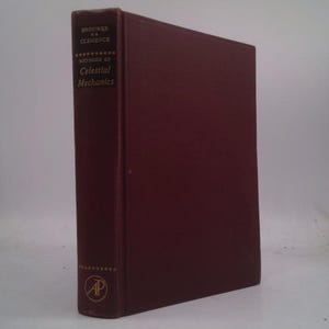 May include: A burgundy hardcover book with gold lettering on the spine. The title is "Methods of Celestial Mechanics" by Brouwer & Clemence. The book has a gold "AP" logo on the bottom of the spine.