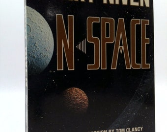 May include: A book cover with a black background and a white title, "Larry Niven N-Space", with an introduction by Tom Clancy. The cover features a blue and white planet, a brown and orange planet, and a black and white galaxy.