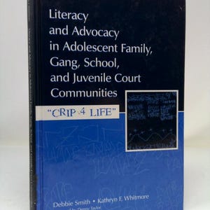 May include: A hardcover book titled "Literacy and Advocacy in Adolescent Family, Gang, School, and Juvenile Court Communities." The cover is dark blue with white text and a blue lower section with graffiti. The text "CRIP 4 LIFE" is also visible.