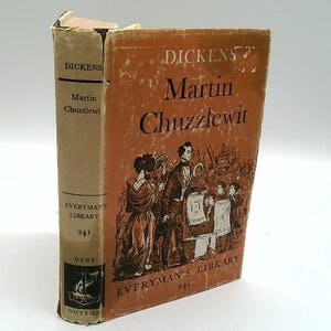 May include: A vintage copy of "Martin Chuzzlewit" by Charles Dickens. The book has a tan spine with the title and author's name. The cover is orange with illustrations and the title. The book is part of the Everyman's Library series.