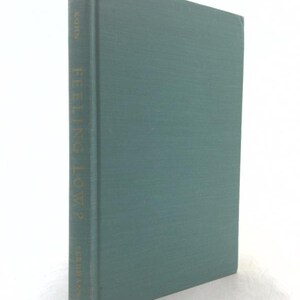 May include: A hardcover book with a solid teal cloth cover. The spine features gold lettering that reads KORN, FEELING LOW?, and EERDMANS. The book is standing upright, showing the front cover and the spine in a clear, vertical orientation.