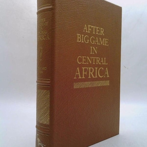 May include: A brown leather-bound book with gold lettering on the spine. The title is "After Big Game in Central Africa".