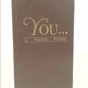 May include: A brown book with the title "You..." by Frances Wilshire.