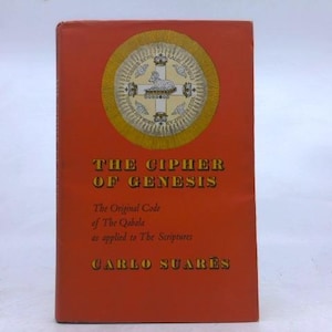 May include: A hardcover book titled "THE CIPHER OF GENESIS" with text in gold lettering on a red cover. The book features an emblem with a cross and a lamb in a gold circle. The author's name, CARLO SUARÈS, is also visible.