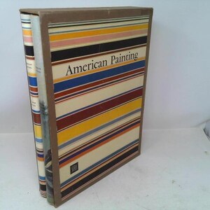 May include: A hardcover book titled "American Painting" with a colorful striped cover in shades of brown, blue, yellow, and red. The book is in a brown cardboard case, with another book visible to the left.