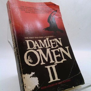 May include: A vintage paperback book titled "Damien Omen II." The cover features a black crow silhouette against a red gradient background. The title is in large white letters, with the number "66" in the center. The book is a spine-chilling new film from 20th Century Fox.
