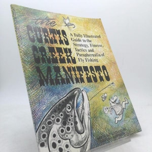 May include: A book titled "The Curtis Creek Manifesto" with a colorful cover featuring a fish illustration and cartoon figures. The book is a guide to fly fishing, with text that reads "A Fully Illustrated Guide to the Strategy, Finesse, Tactics and Paraphernalia of Fly Fishing."