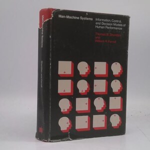 May include: A hardcover book titled "Man-Machine Systems" with a black cover. The cover features a pattern of white head silhouettes and red squares. The book's spine is visible, with the title and author's names.