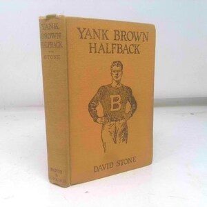 May include: A vintage book titled "Yank Brown Halfback" by David Stone. The cover is a tan color with a drawing of a football player wearing a letter "B" on his shirt. The book's spine also has text.