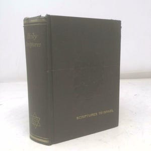 May include: A dark green book with the words "Holy Scriptures" on the spine. The cover has the text "Scriptures to Israel" and a Star of David symbol. The book is standing upright.