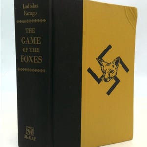 May include: A black and gold hardcover book titled "The Game of the Foxes" by Ladislas Farago. The book cover features a black and white illustration of a fox inside a swastika.