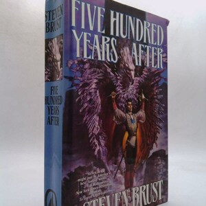 May include: A book cover with a purple background and a large image of a winged figure holding a sword. The title "Five Hundred Years After" is printed in white letters. The author's name, "Steven Brust", is printed in white letters at the bottom of the cover.
