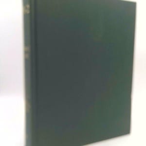 May include: A hardcover book with a dark green cover. The spine has gold lettering. The book is standing upright against a white background. The cover is smooth and appears to be in good condition.