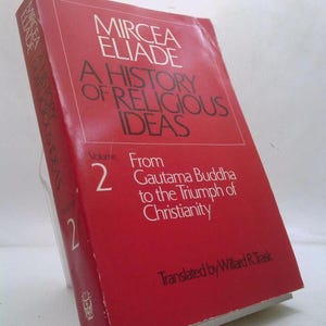 May include: A red book titled "A History of Religious Ideas" by Mircea Eliade. Volume 2, subtitled "From Gautama Buddha to the Triumph of Christianity," is visible. The book's cover features white text and a rectangular design.