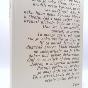 May include: A hardcover book with a white cover and text in a foreign language. The text is in a dark gray color. The author's name, Tito, is at the bottom right corner of the book.