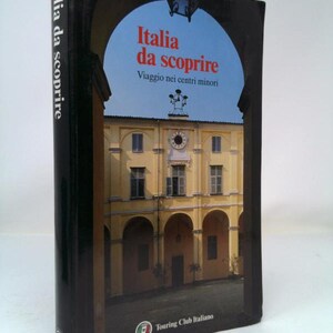 May include: A black book with the title "Italia da scoprire" and the subtitle "Viaggio nei centri minori" on the cover. The cover also features a photo of a yellow building with arched doorways.