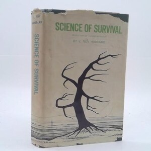 May include: A hardcover book titled Science of Survival by L. Ron Hubbard with a beige dust jacket featuring a black illustration of a bare tree on a landscape. The title is printed in green text on the front cover and blue on the spine.