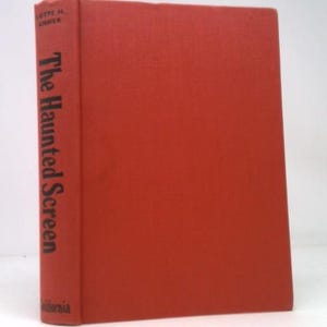 May include: A hardcover book titled "The Haunted Screen" with a solid red cover. The spine features the title in black text and the author's name. The book is set against a white background.