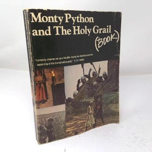 May include: A black paperback book titled Monty Python and The Holy Grail (Book) with a white title and a quote by E. Heath. The cover features a collage of film stills showing medieval characters, knights in helmets, and a castle scene.