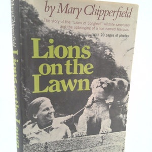 May include: A book cover with a photo of a woman walking two lion cubs on a leash. The book title is "Lions on the Lawn" and the author is Mary Chipperfield. The book cover also includes the text "The story of the "Lions of Longleat" wildlife sanctuary and the upbringing of a lion named Marquis. With 20 pages of photos."