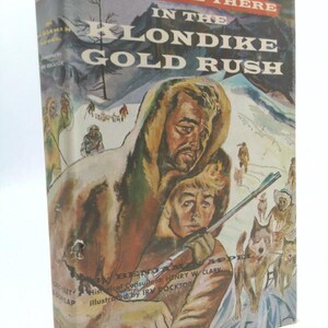 May include: Vintage book cover titled "We Were There in the Klondike Gold Rush." The cover art depicts two men in fur-lined coats, a rifle, and a dog sled team. The book is by Benjamin Appel and illustrated by Irv Docktor.