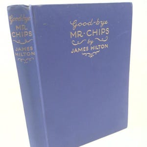 May include: A hardcover book titled "Good-bye Mr. Chips" by James Hilton. The book has a blue cover with gold lettering. The spine also features the title and author's name. The publisher's logo is at the bottom of the spine.