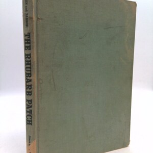 May include: A green hardcover book titled "The Rhubarb Patch" by Stern and Haeber. The book is slightly worn and has a faded spine.