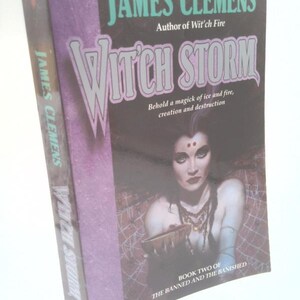 May include: A paperback book titled "Witch Storm" by James Clemens. The cover features a woman with dark hair and jewelry, holding a bowl. Text includes "Behold a magick of ice and fire, creation and destruction."