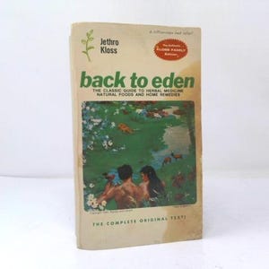 May include: A paperback book titled Back to Eden by Jethro Kloss with a beige cover. The cover features a green plant icon, a red oval badge, and a central illustration of two figures in a lush green landscape with flowers and small animals.