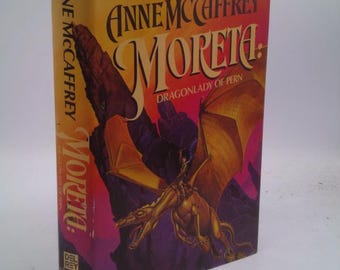 May include: A book cover with a yellow, orange, and red background. The title "Moreta: Dragonlady of Pern" is in large, bold, gold letters. A dragon is flying in the background.