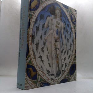 May include: A hardcover book titled "Codices Illustres" with a light blue spine. The cover features a detailed illustration of two figures within a celestial map design, with blue, white, and gold accents. The book is from the publisher Taschen.