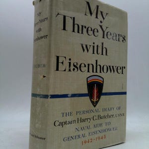 May include: A hardcover book titled "My Three Years with Eisenhower" with the author's name and the subtitle "The Personal Diary of Captain Harry C. Butcher, USNR, Naval Aide to General Eisenhower 1942-1945." The book has a light beige cover.