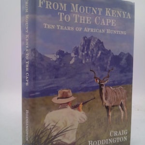 May include: A hardcover book titled "From Mount Kenya To The Cape" with the subtitle "Ten Years of African Hunting." The cover features a hunter aiming a rifle at an animal, with a mountain range in the background.