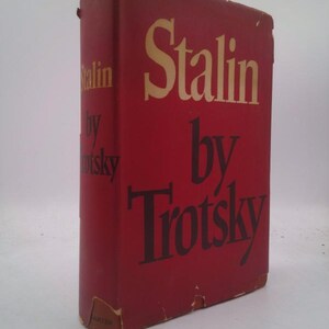 May include: A vintage hardcover book titled "Stalin by Trotsky." The book has a red cover with the title in gold and black lettering. The book's spine and edges show signs of wear.