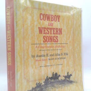 May include: A hardcover book titled "Cowboy and Western Songs" with a light yellow cover and red text. The book features a comprehensive anthology of songs, with illustrations of cowboys on horseback at the bottom.