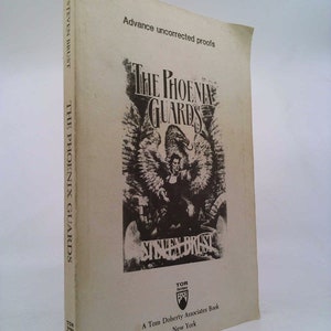 May include: Advance uncorrected proofs cover of a fantasy novel titled "The Phoenix Guards" by Steven Brust. The cover features a black and white illustration of a winged figure with a sword.