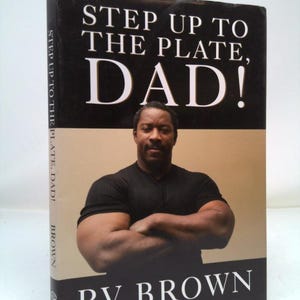 May include: A book cover with the title "STEP UP TO THE PLATE, DAD!" in white letters on a black background. The author's name, RV BROWN, is at the bottom. The cover features a photo of a man with crossed arms.