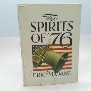May include: A vintage book titled "The Spirits of '76" by Eric Sloane. The cover features a depiction of the Liberty Bell and an American flag. The book has a cream-colored cover with black and red text.