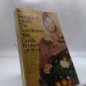 May include: A vintage book titled "Beauty and Health The Scandinavian Way" by Gunilla Knutson. The cover features a woman with blonde hair and a basket of produce. The book promises a guide to natural beauty and vitality.