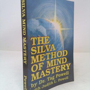 May include: A hardcover book titled "The Silva Method of Mind Mastery" by Dr. Tag Powell and Judith L. Powell. The book has a blue cover with a globe and a bright light burst. The spine reads "Silva Mind Mastery" and "Powell".