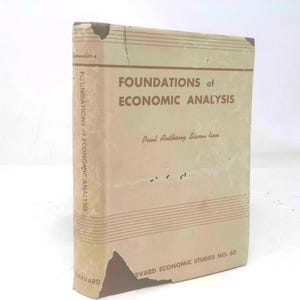 May include: A vintage book titled "FOUNDATIONS of ECONOMIC ANALYSIS" by Paul Anthony Samuelson. The book has a beige cover with brown text and horizontal lines. The book is part of the Harvard Economic Studies series.