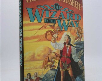 May include: A book cover with a yellow, orange, and blue background. The title is "A Wizard in the Way" with a dragon in the background. The author is Christopher Stasheff.